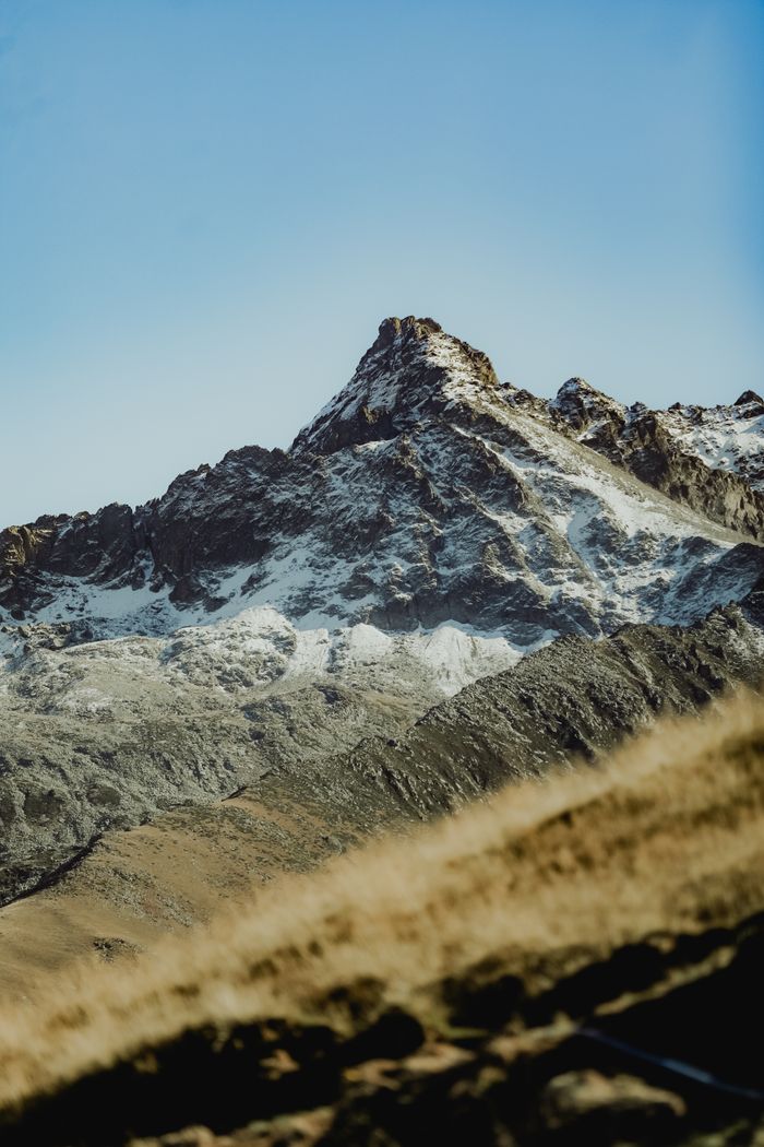 Majestic snow-covered mountain peak under clear blue sky, showcasing natural beauty and tranquility.